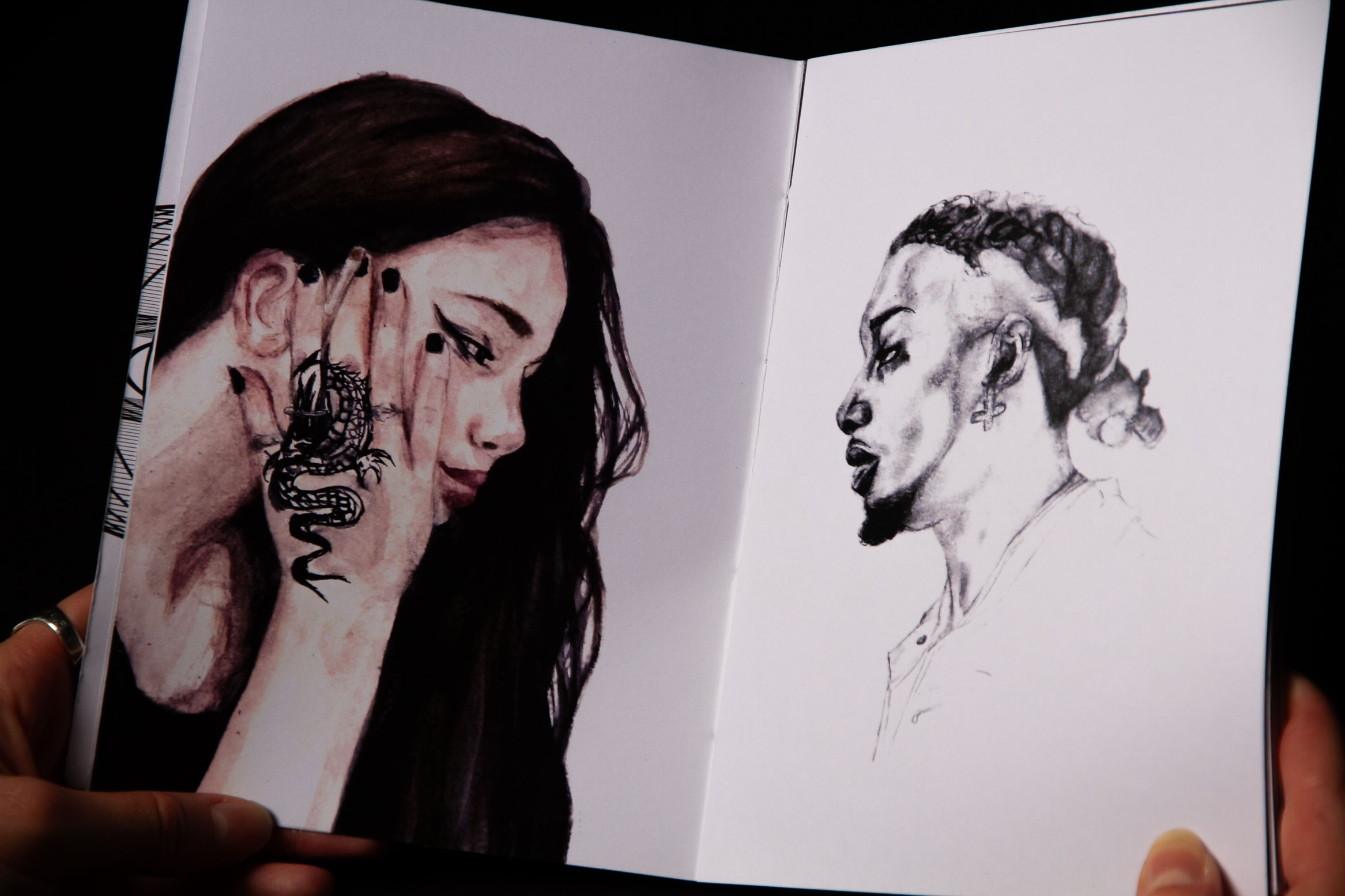 image de catalogue ouvert avec le visage peint d'une femme, tatouage à la main, faisant face au visage au crayon de papier d'un homme