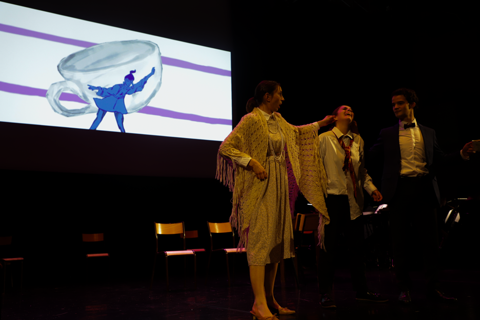 photo du spectacle l'enfant et les sortilèges du conservatoire à rayonnement régional de boulogne, dame en premier plan et écran et chaises en fond