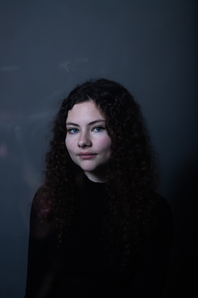 photo de jeune fille aux cheveux bouclés et aux yeux bleus dans une ambiance bleutée